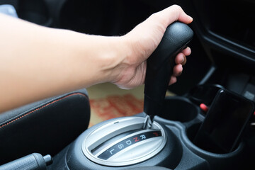 A car driver shifting the automatic transmission