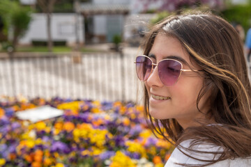 A happy young girl with a background of colorful flowers