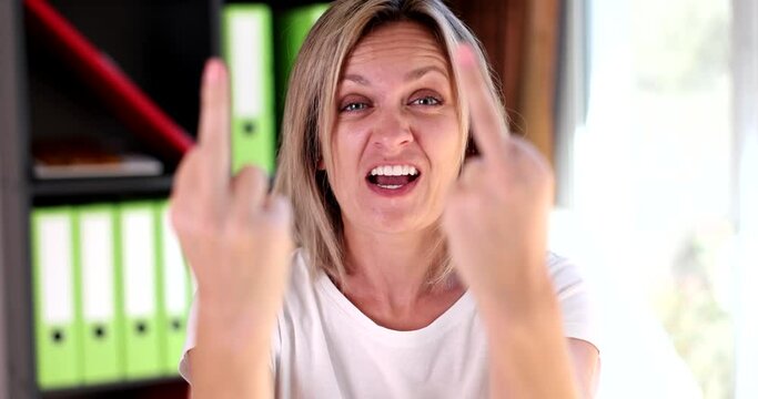 Beautiful angry aggressive woman showing middle finger, making a fuck you bad expression. Woman provocative and rude attitude and screaming excited