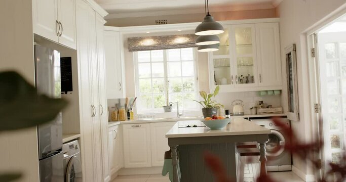 Kitchen island, lamps, furnitures, fringe and windows in sunny kitchen, slow motion