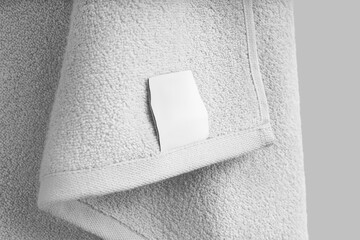 Mockup of a textured white towel with a label, close-up, for design, branding. Product photography.