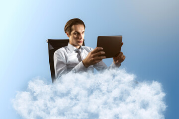 Young caucasian businessman using tablet on cloud. Blue sky background. Dream big, business and strategy, forethought and vision concept.