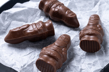 cheerful wrapped chocolate Santa Claus on wooden table. Close up