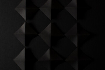 Black 3d geometric shapes on black background, top view