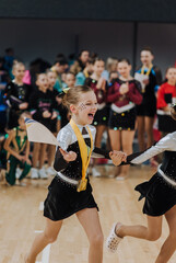 Beautiful happy professional sportswoman, little girl gymnast rejoices in victory in the gym at...