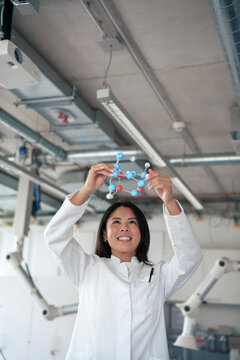 Happy scientist examining molecular structure at laboratory