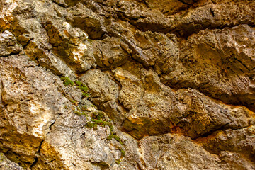 Natural rock texture background. Rocky bas-relief wall.