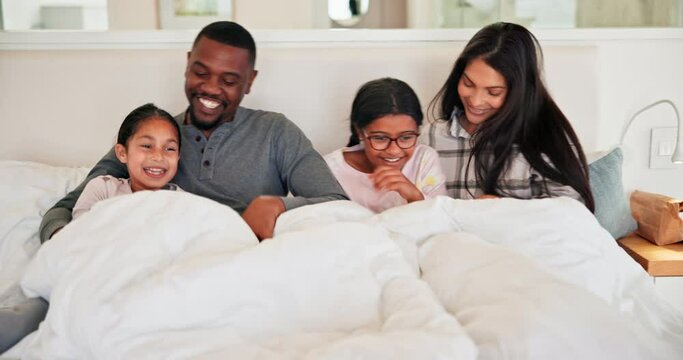 Funny, family and kids in bedroom, tickle and play, bonding and happy together in the morning in home. Laughing children, mother and father in bed, smile and care of interracial people under blanket
