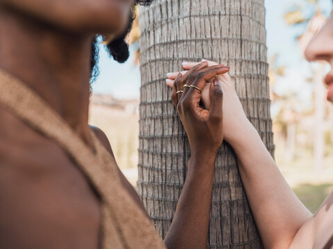 Friends holding hands and touching tree