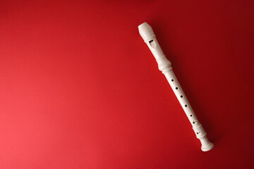 White plastic recorder on red gradient background © Davizro Photography