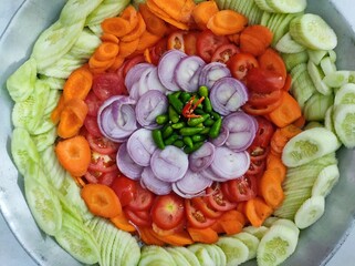 Salad with chilli, onion, tomato, carrot and cucumber on a plate