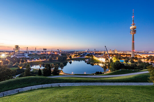 Germany, Bavaria, Munich, Olympic Park at dusk with Olympic Tower, BMW Building and pond in background