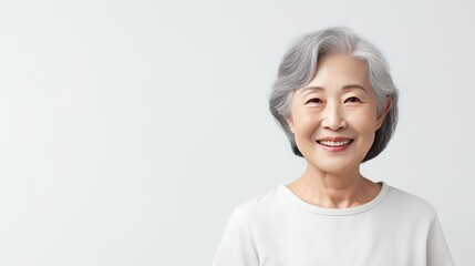 Asian gorgeous mature woman with natural makeup and gray hair. Smiling confident aging model on white background