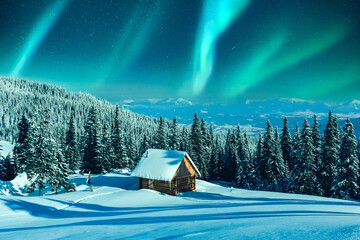 A mountainous winter vista with a rustic cabin and snow-laden pine trees on a meadow. Aurora borealis. Northern lights in winter forest. Christmas holiday and winter vacations concept