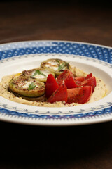 Obraz na płótnie Canvas Vegan meal plate with fresh tomatoes, mashed potato and stuffed baked eggplant