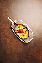 Frying pan with tomato and fried eggs with cheese