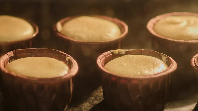 The process of making muffins in the oven, timelapse. Cupcake dough rises at the moment of baking in the home kitchen
