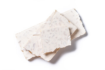 Traditional Christmas sweet, pieces of delicious almond nougat isolated on white background. Top view