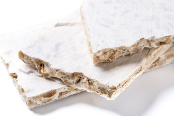 Traditional Christmas sweet, pieces of delicious almond nougat isolated on white background