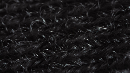 Texture of black woolen fabric. Close up photo, ultra macro magnification of intertwined wool...