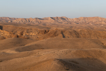 Fototapeta na wymiar Early morning light on the brown and barren Judean Desert in Israel