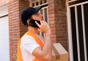 Delivery man calling the customer to check his house address. The man seems to be lost and surprised because this inefficiency causes a waste of time.