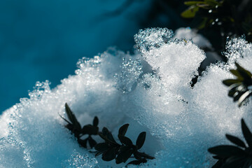 Close-up of large piles of melting snow. Snowflakes and ice lit by the sun. Cold temperatures in...