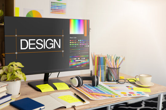 Graphic designer's workspace with a computer and creative tools on the table