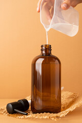 Recycled plastic pump bottle for mockup. woman pouring liquid soap from plastic measure cup to bottle