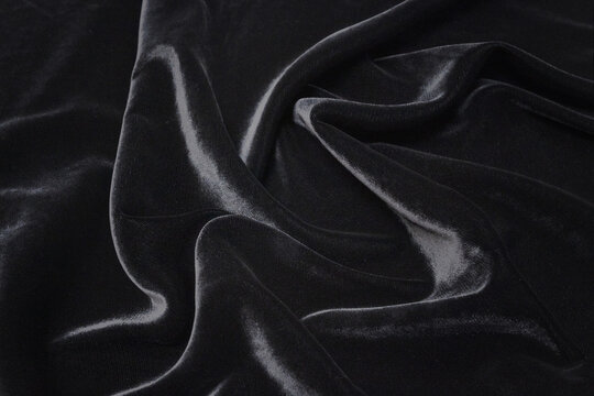 Abstract background texture of natural black color fabric. Fabric texture of natural cotton or linen, silk or satin, wool or jersey textile material. Luxurious dark gray canvas background..