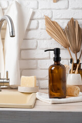 Recycled plastic pump bottle for mockup on white brick wall background near sink