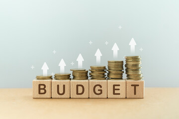 step of stack of coins on wooden cube blocks with budget text and up arrow, for planning annual...