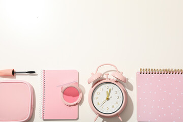 Decorative cosmetics, alarm clock and notepads on white background, space for text