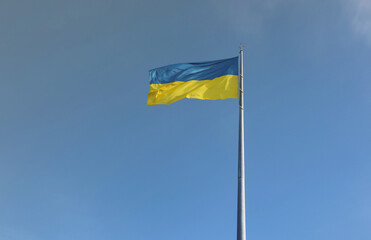 Ukrainian flag isolated on the blue sky with clipping path. Close up waving banner of Ukraine. Tall flag symbol of Ukraine, european country of freedom