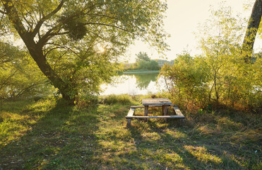 Obraz premium Beautiful autumn landscape with sunset among the green and orange trees. Picturesque place with lake and wood