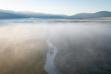 Early morning just after sunrise. Fog in the valley of the Chuya River. Magic landscape in the Kurai steppe. Summer landscape in Altai mountains, Siberia, Russia.