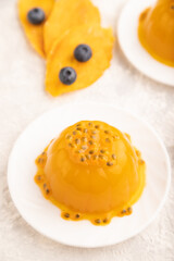 Mango and passion fruit jelly with blueberry on gray concrete, side view, selective focus.