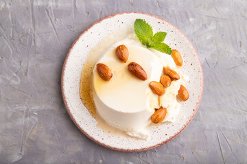 Ricotta cheese with honey and almonds on gray concrete. top view, flat lay, close up.