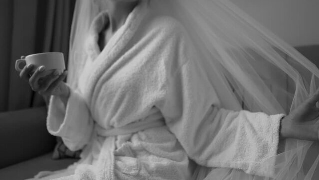 Beautiful veil of the bride close-up in a wedding dress in the morning before the ceremony, sexy girl with a cup of coffee in the hotel