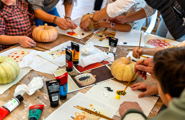 Children's painting class. Painting day with parents in class painting pumpkins.