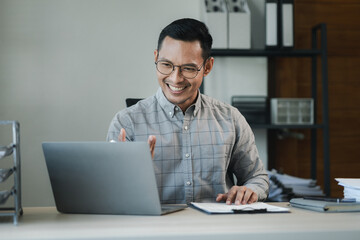 Businessman is sitting and working in the office, Employee is looking for information on laptop, An entrepreneur is talking on the phone with a company customer, startup.