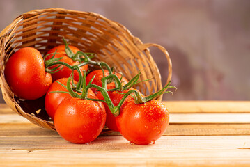 Tomatoes, beautiful arrangement with tomatoes in a basket on rustic wood, selective focus.