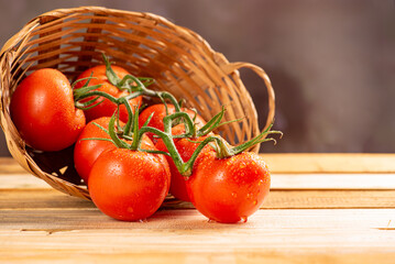 Tomatoes, beautiful arrangement with tomatoes in a basket on rustic wood, selective focus.