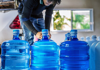 Drinking water clear and clean in blue gallon arranged in a row Prepare to lift into the back of a...