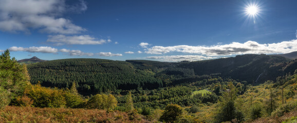 Large panorama with Powerscourt Waterfall, valley, forests in autumn colours and Sugarloaf...