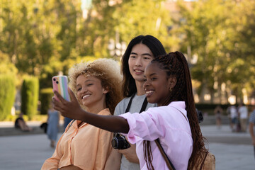 Group of three multi ethnic friends taking selfie with a smart phone