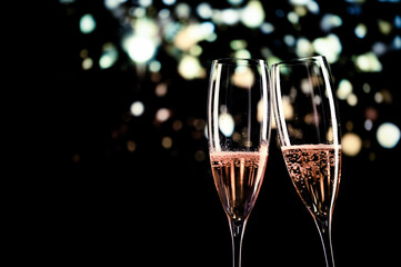 two champagne glasses and festive light happy New Year