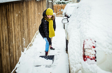 woman with shovel cleaning snow. Winter shoveling. Removing snow after blizzard