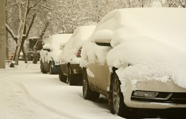 Fragment of the car under a layer of snow after a heavy snowfall. The body of the car is covered with white snow