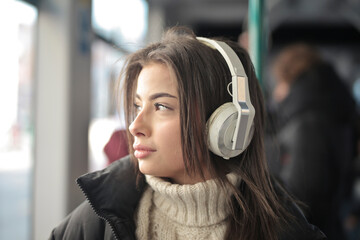 young woman listens to music on the train